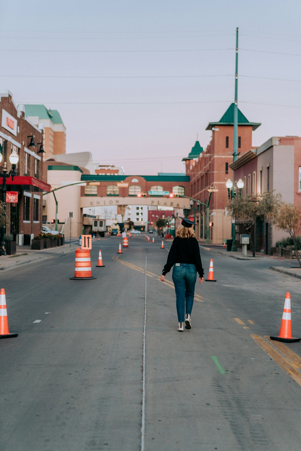 woman in black coat walking on sidewalk during daytime