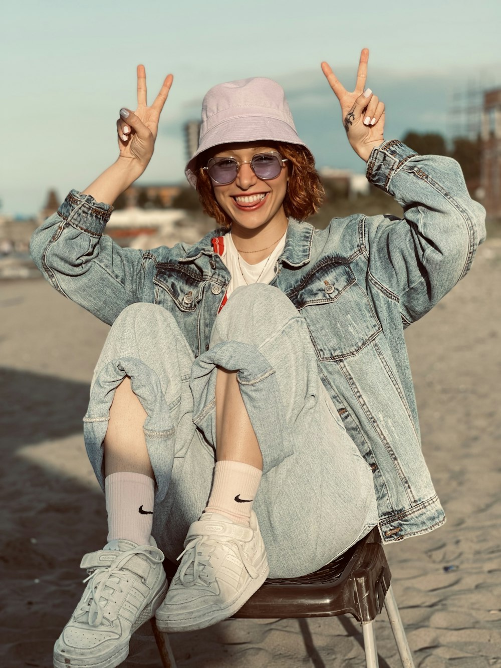 a woman sitting in a chair with her hands up