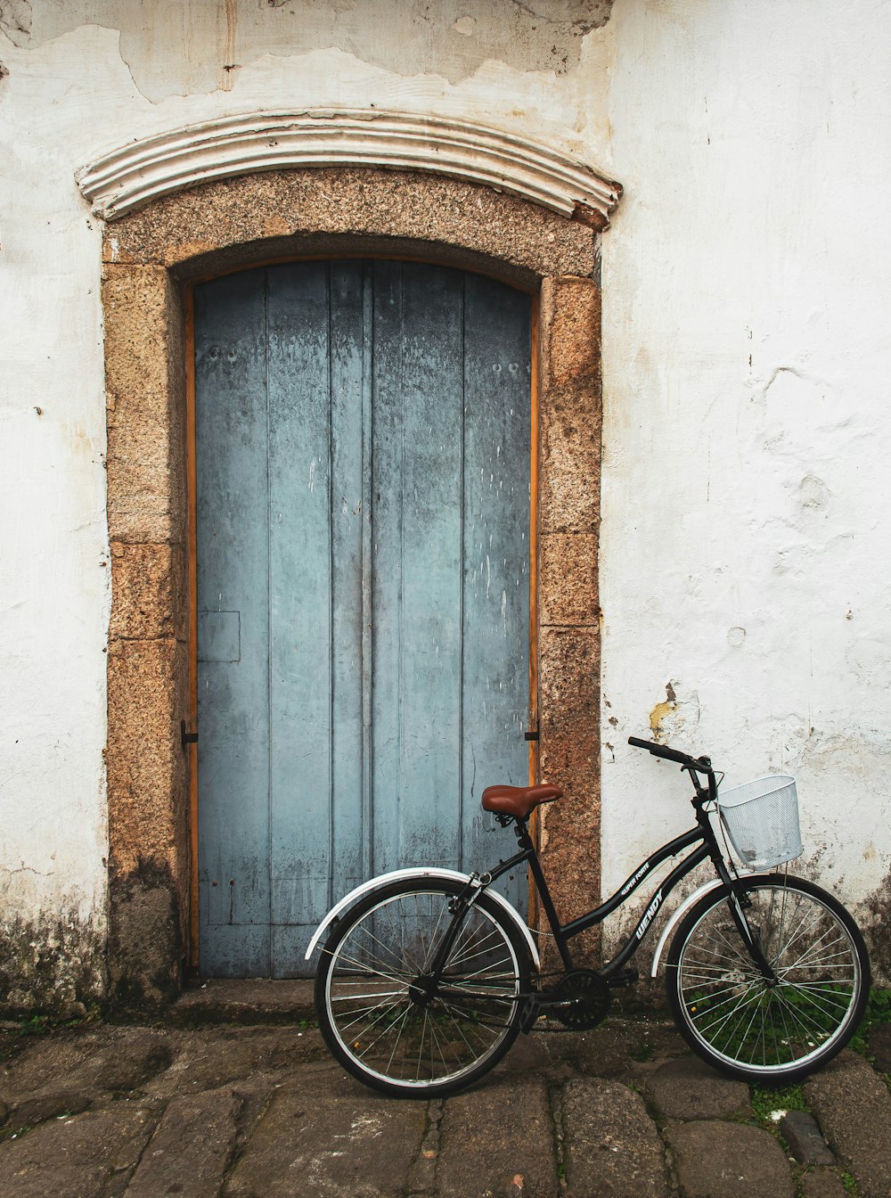 a bicycle parked in front of a blue door