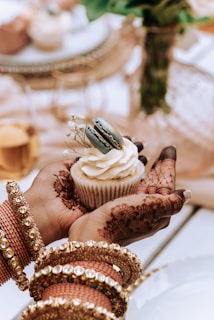 a person holding a cupcake in their hand