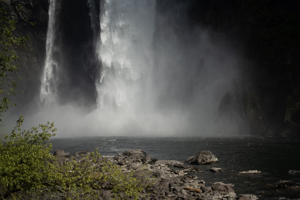 a large waterfall in the middle of a body of water