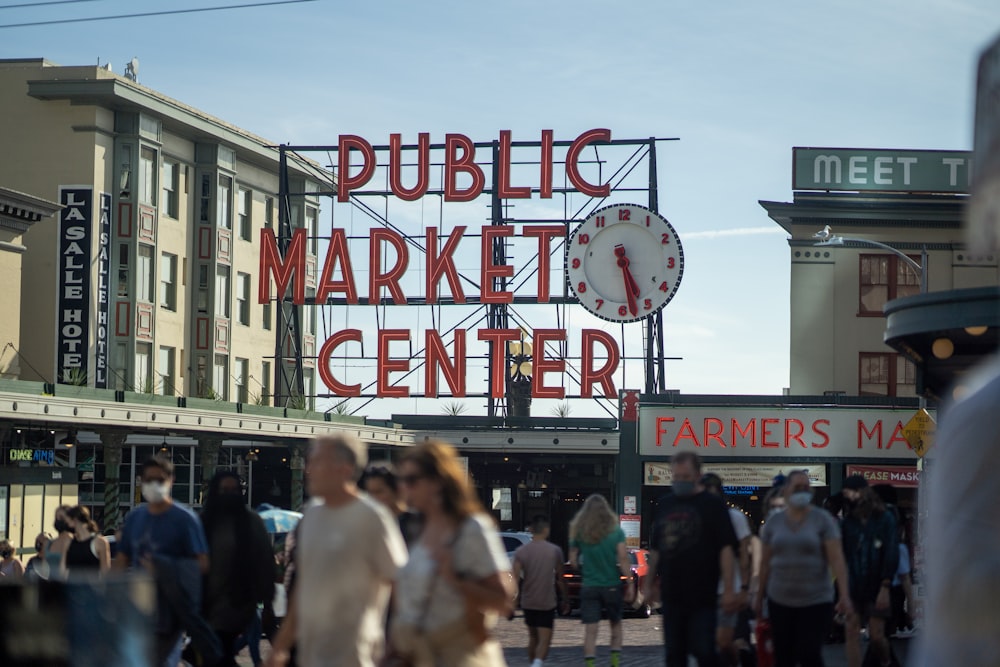 a crowd of people walking around a public market center