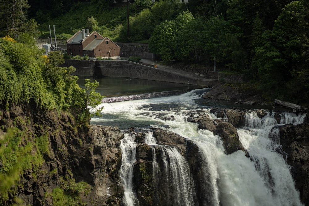 a waterfall with a house in the background