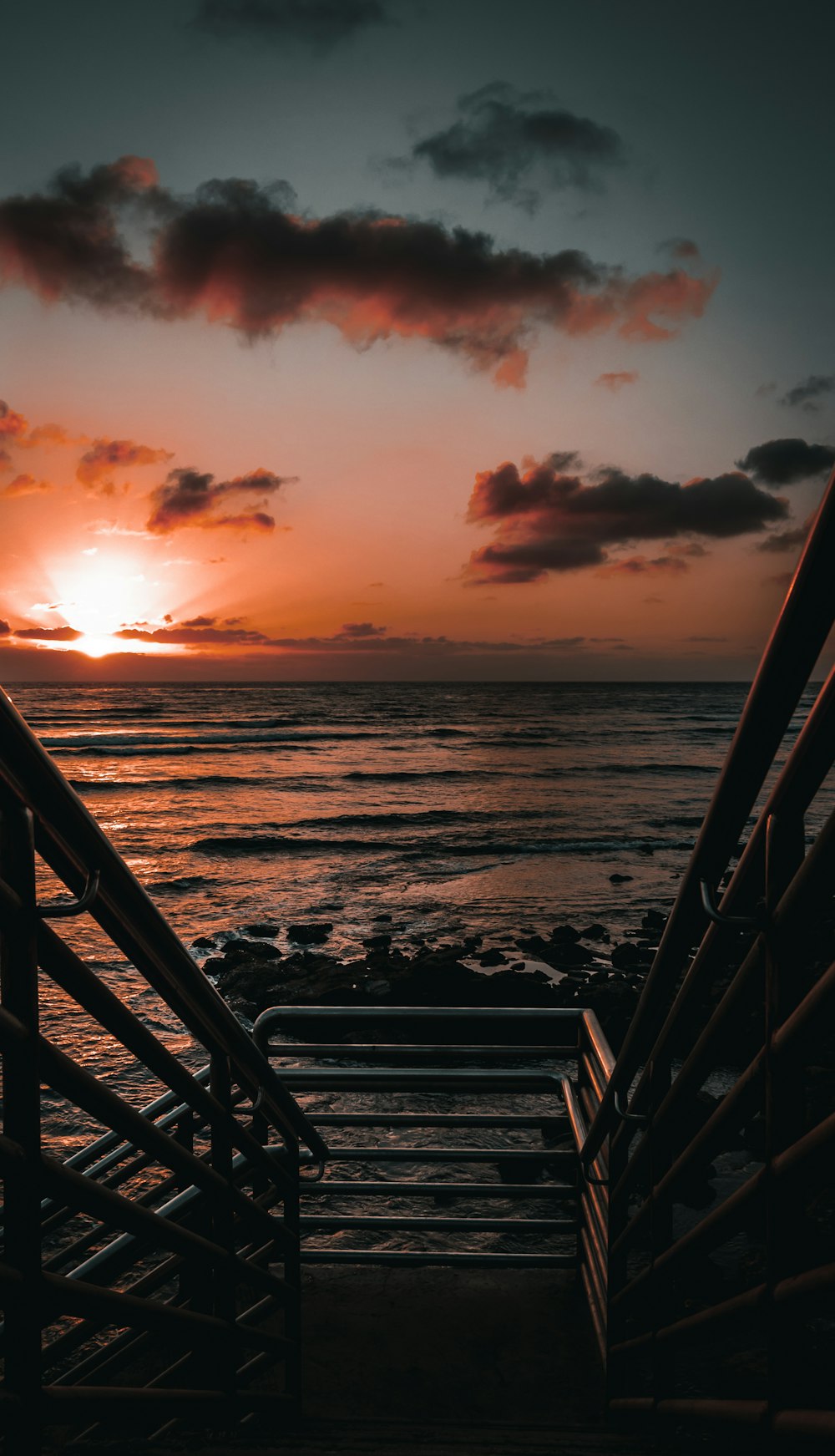 silhouette of a person standing on a beach during sunset