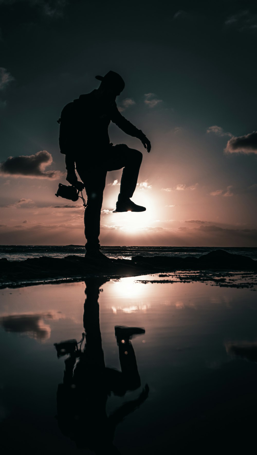 a silhouette of a person jumping in the air