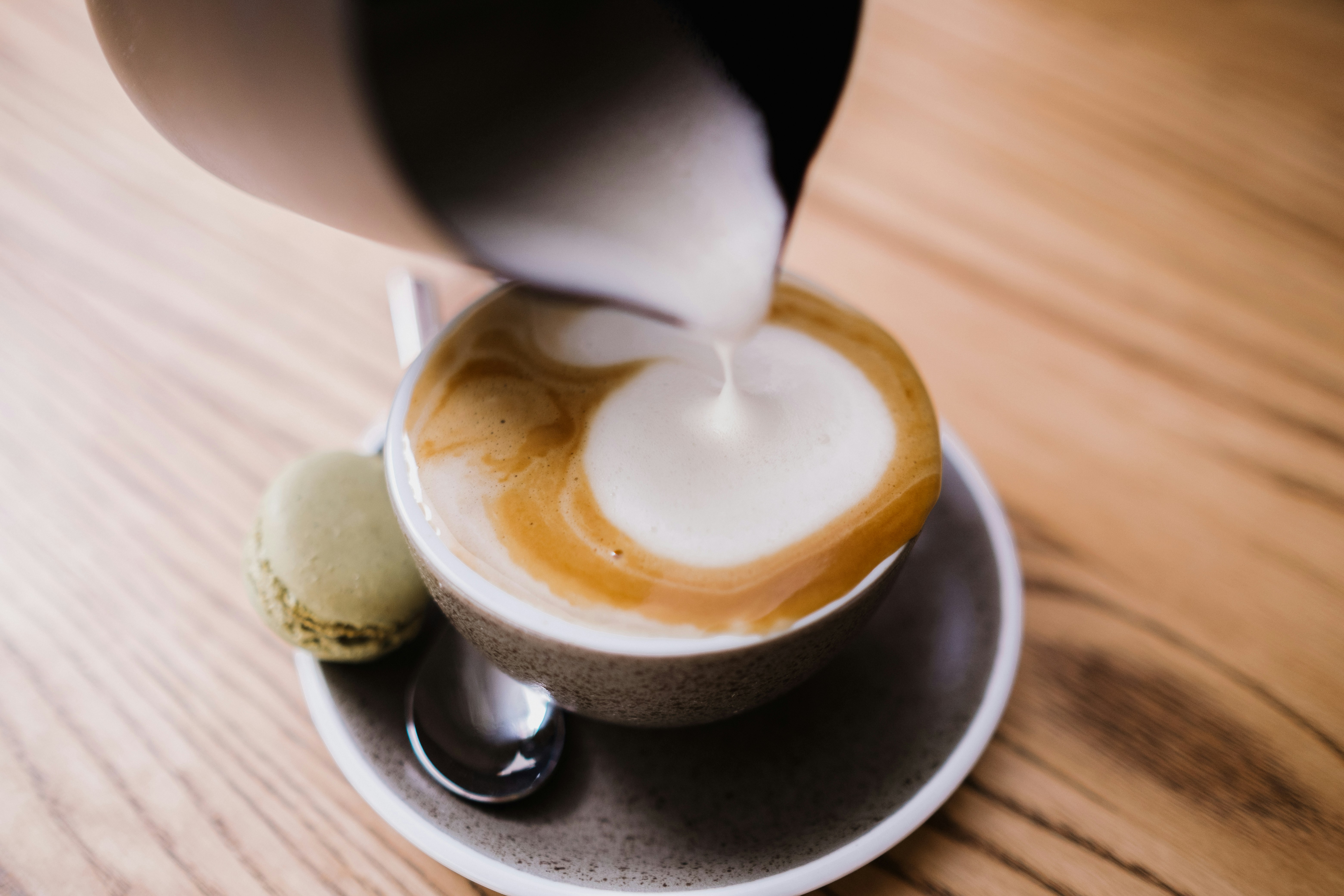 Steamed milk poured into a cup on a saucer