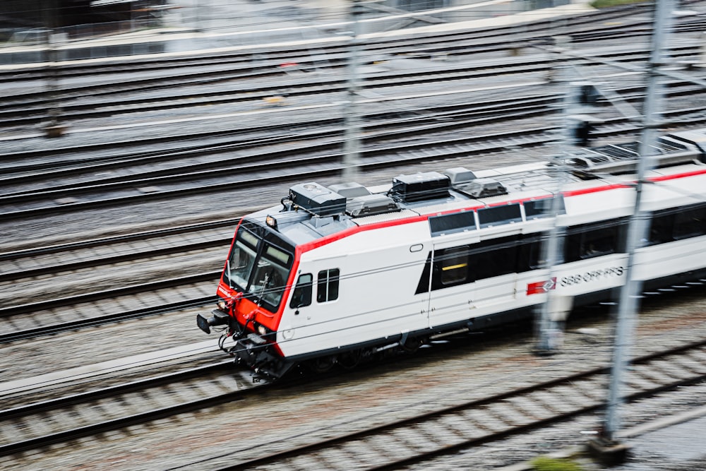 um trem branco e vermelho viajando pelos trilhos do trem