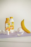 a banana and two bottles of juice on a table