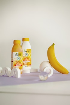 a banana and two bottles of juice on a table