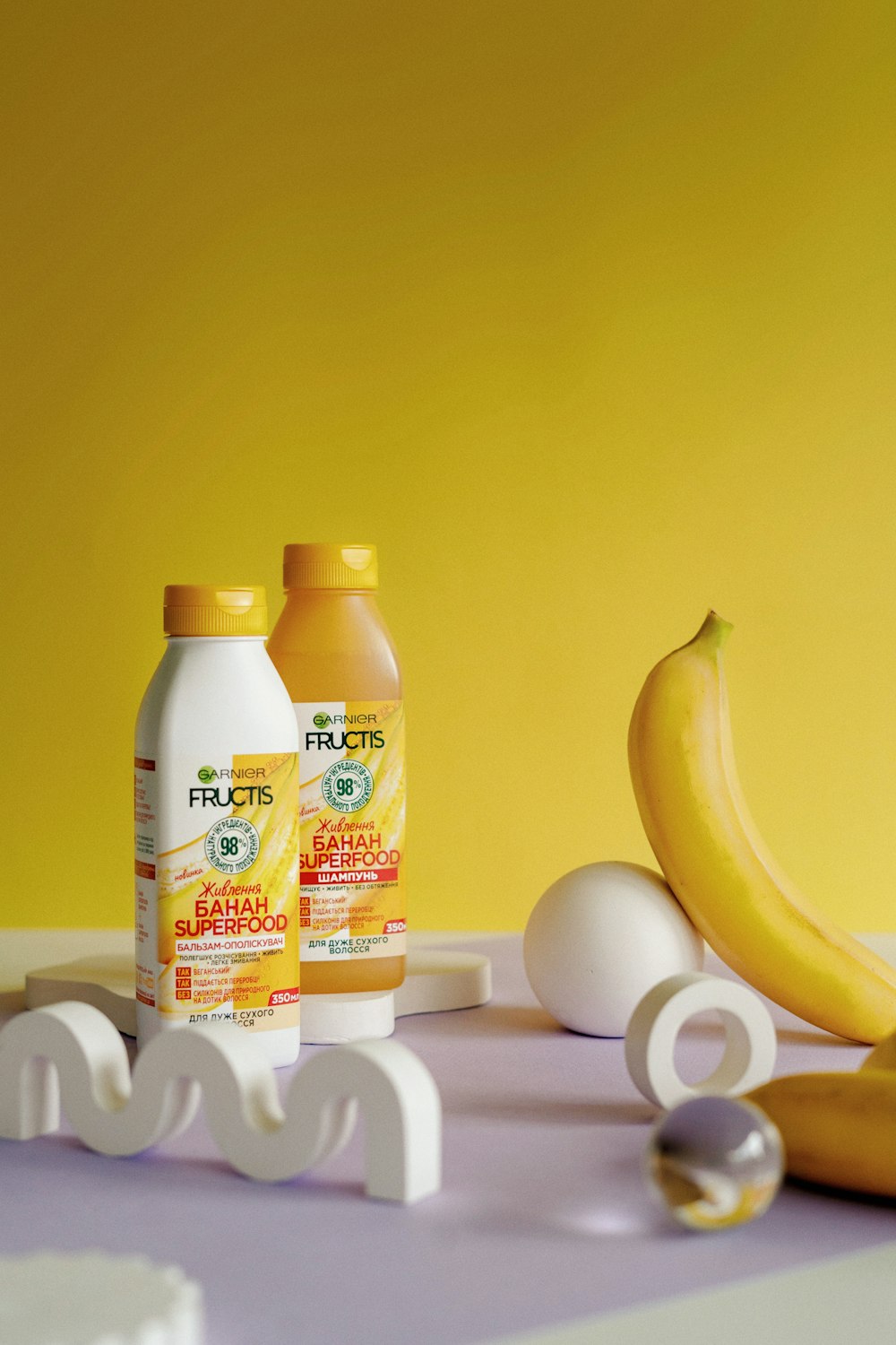 a couple of bottles of juice next to a banana