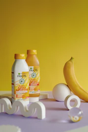 a banana, eggs, and two bottles of juice on a table