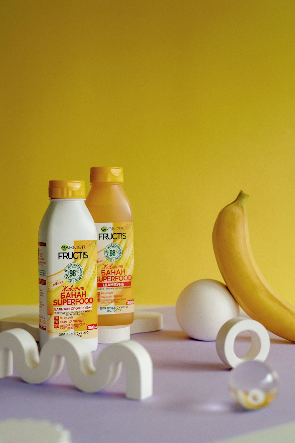 une banane, des œufs et deux bouteilles de jus sur une table