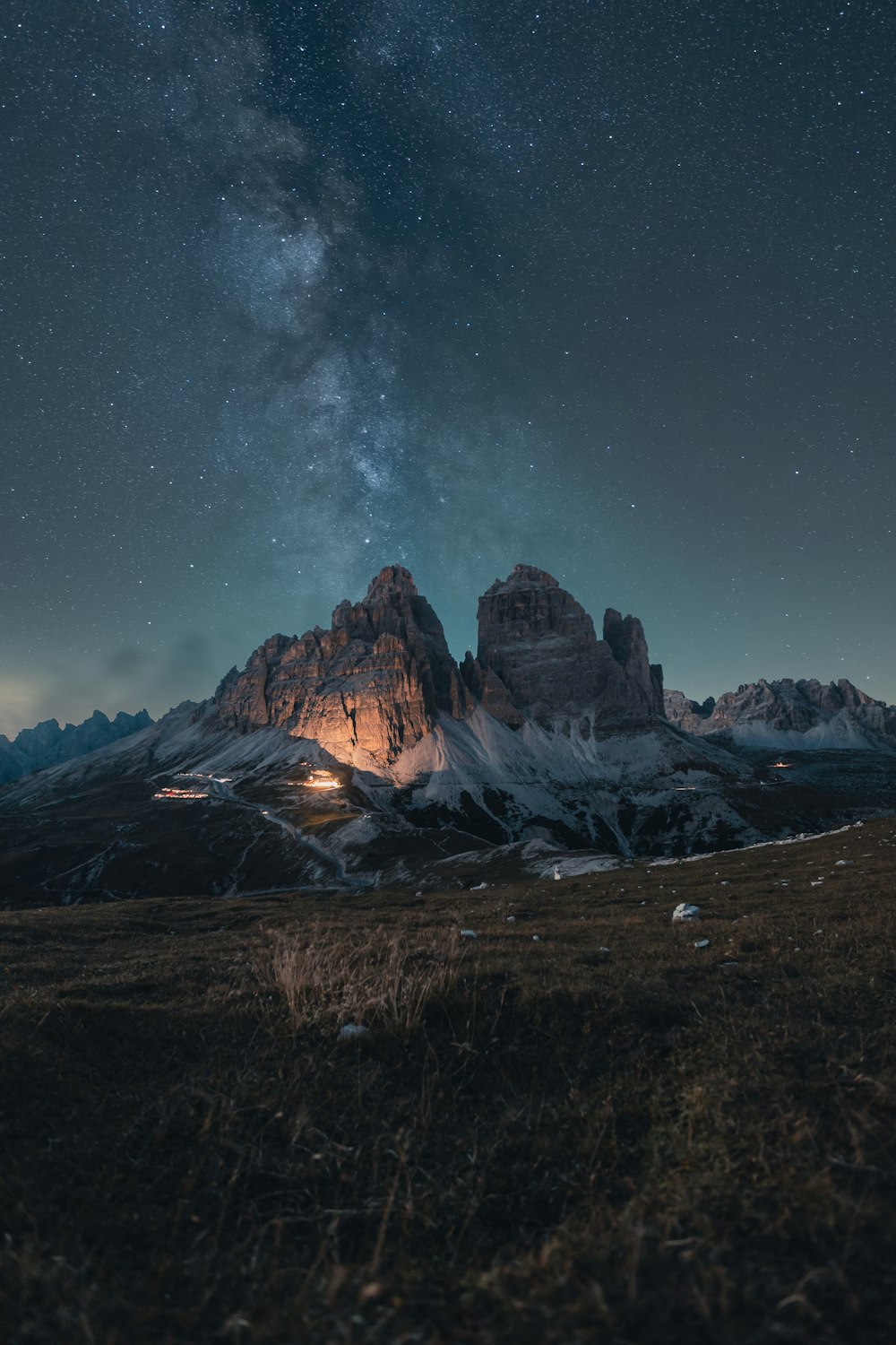 the night sky with stars above a mountain range