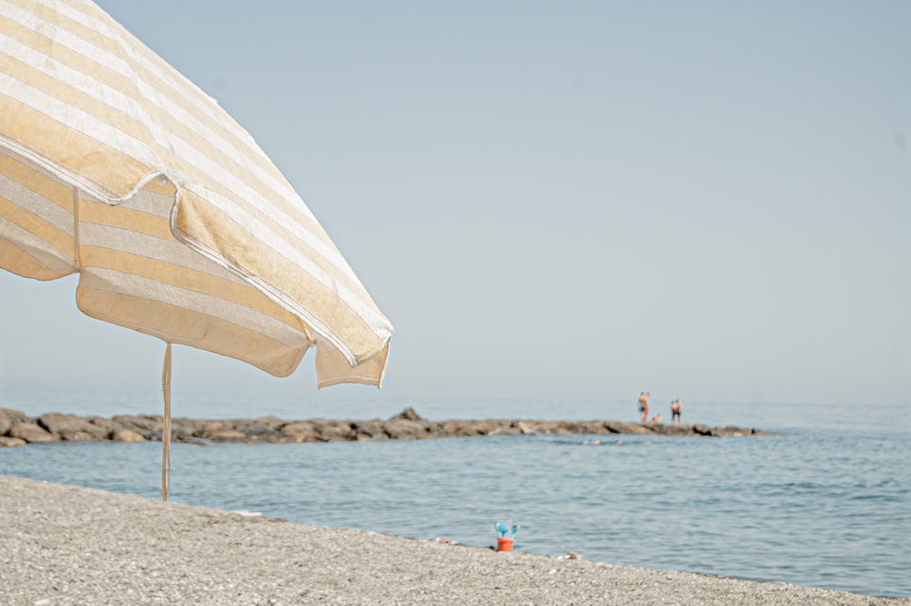 a beach umbrella sitting on top of a sandy beach