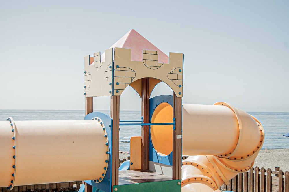 a play structure on the beach with a view of the ocean