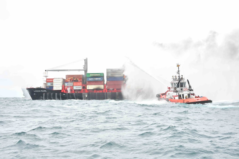 a tug boat spraying water on a large ship