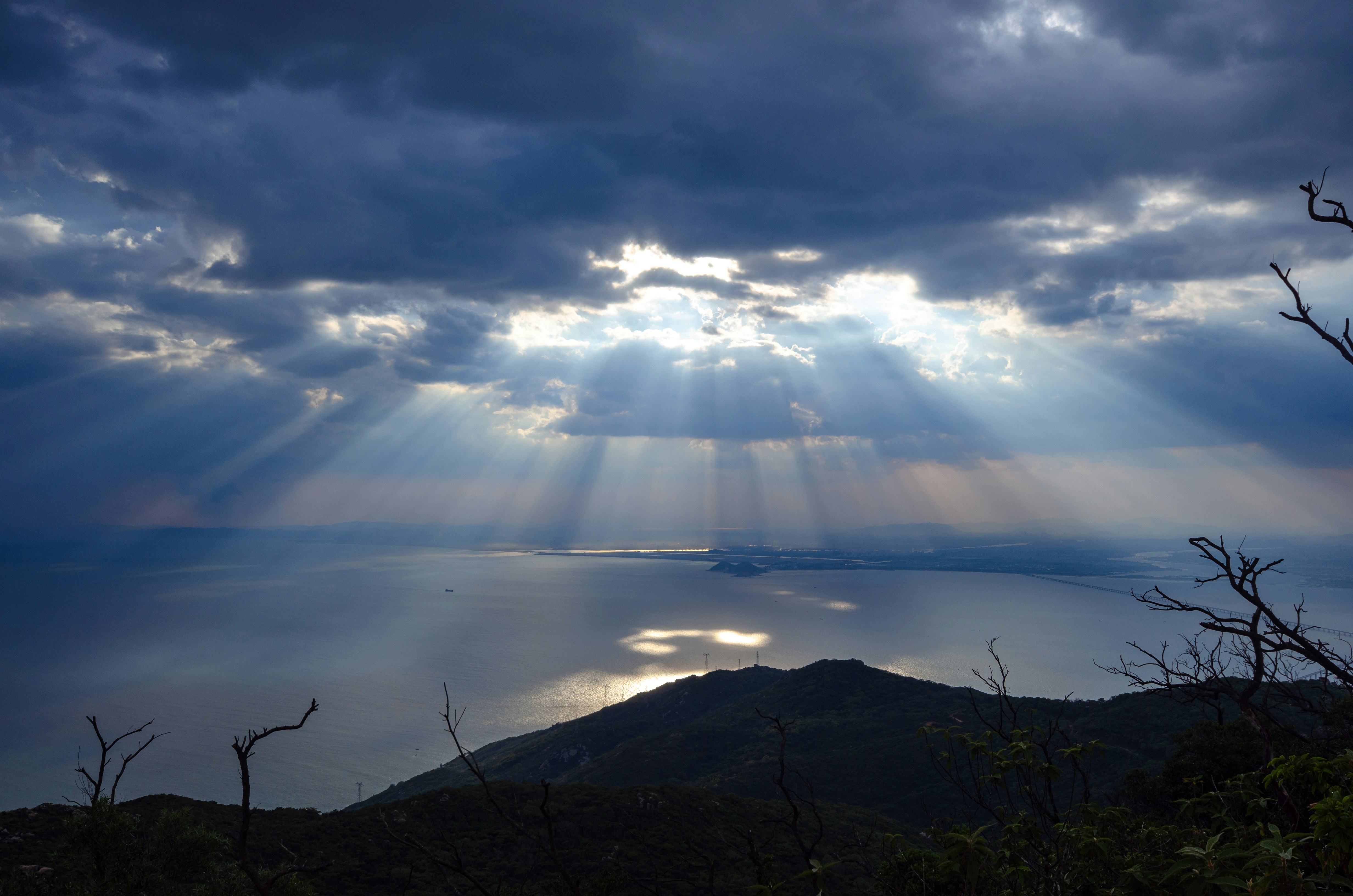 the sun is shining through the clouds over the water
