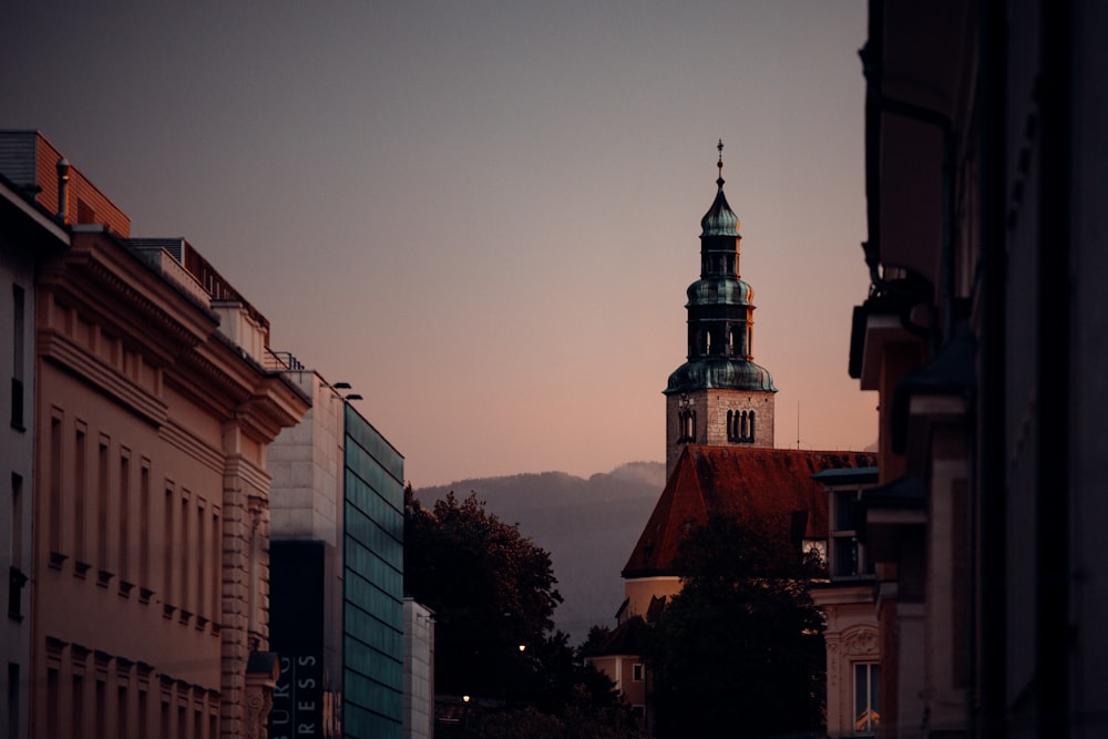 a church steeple in a city at dusk