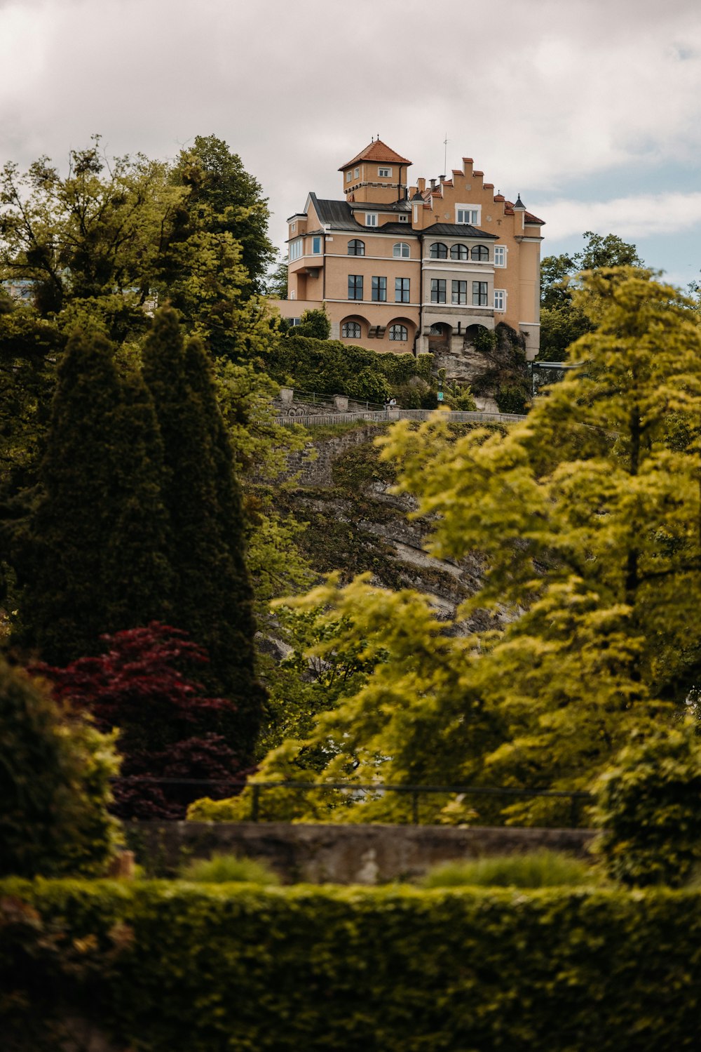 a large house sitting on top of a lush green hillside