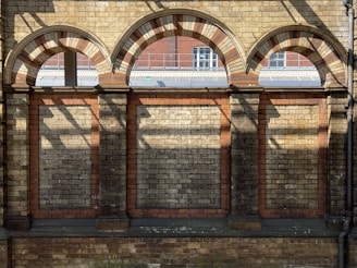 a brick building with arched windows and a bench in front of it