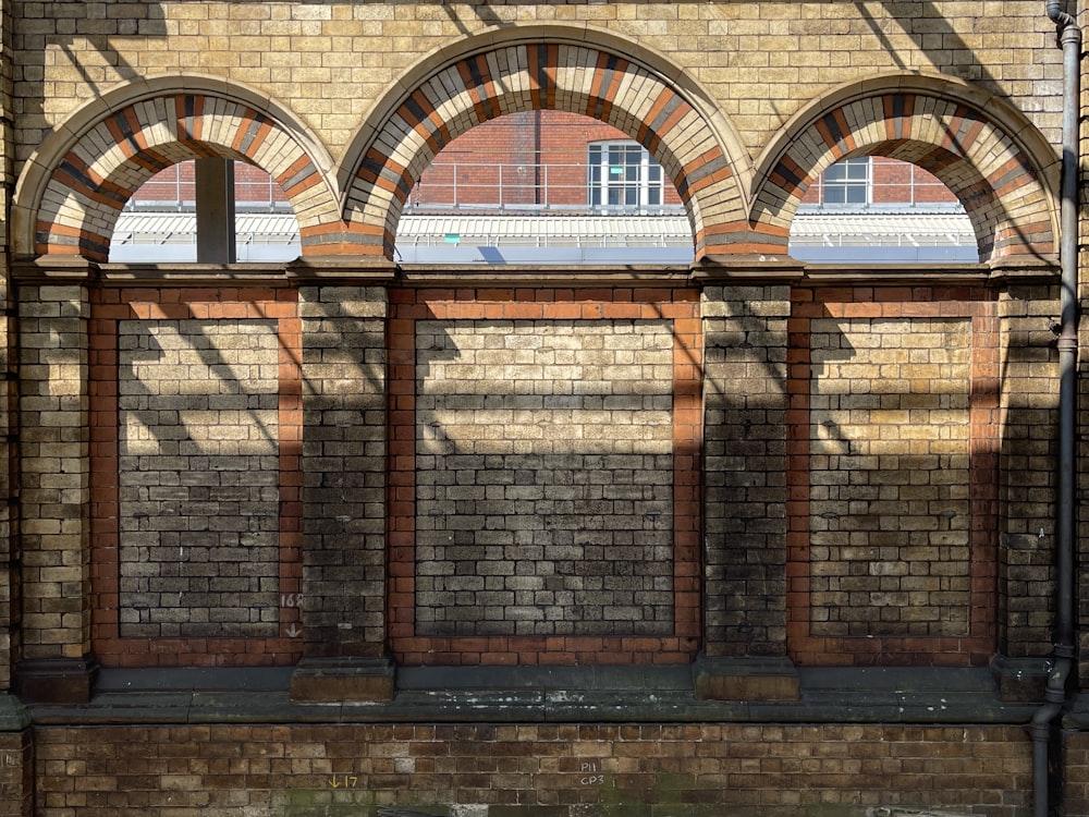 a brick building with arched windows and a bench in front of it