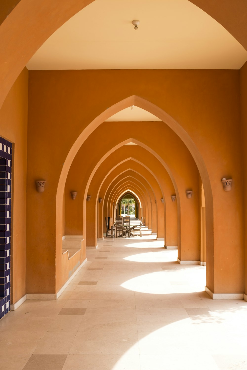 a walkway lined with arches leading to a restaurant