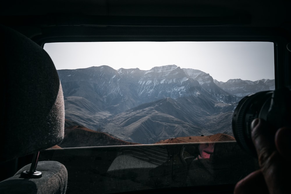 a view of a mountain range from inside a vehicle