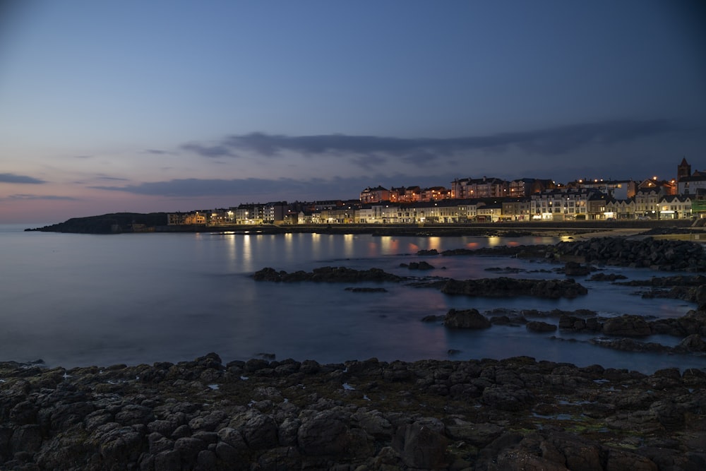 a night view of a beach with a city in the background