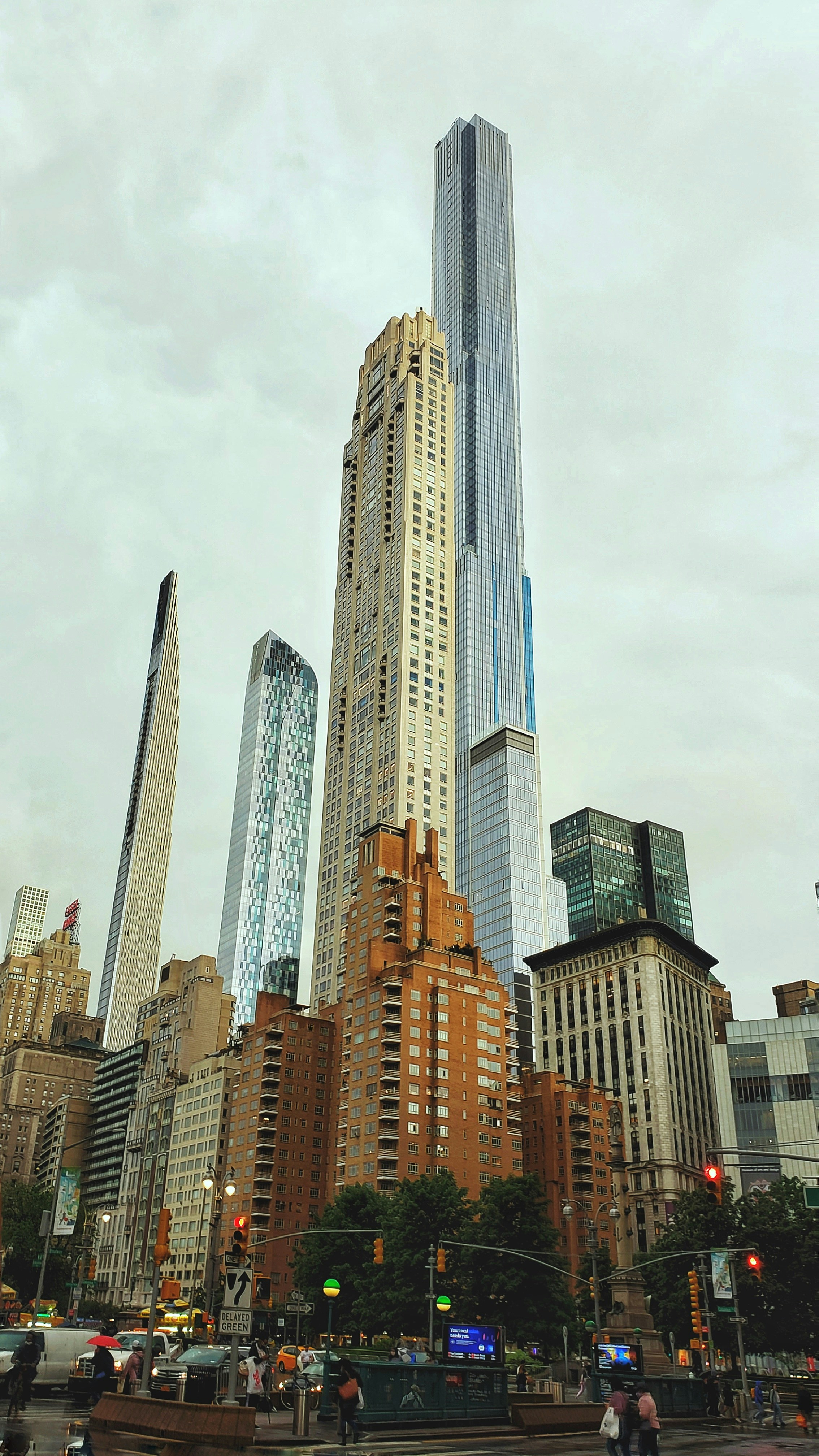 a group of people crossing a street in front of tall buildings