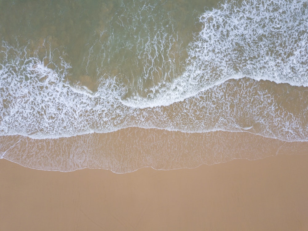 una vista aerea di una spiaggia con onde che entrano