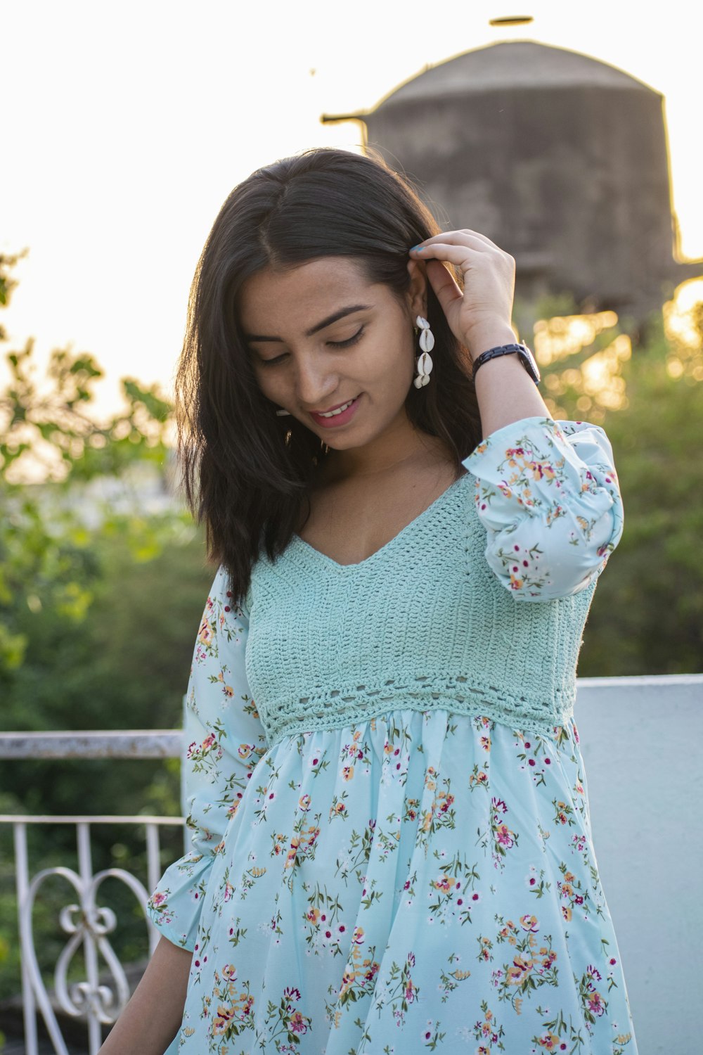 a woman in a blue dress is looking down at her hair