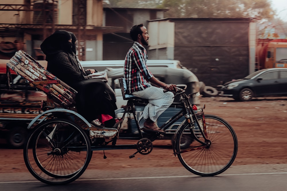 a man riding a bike with a woman on the back