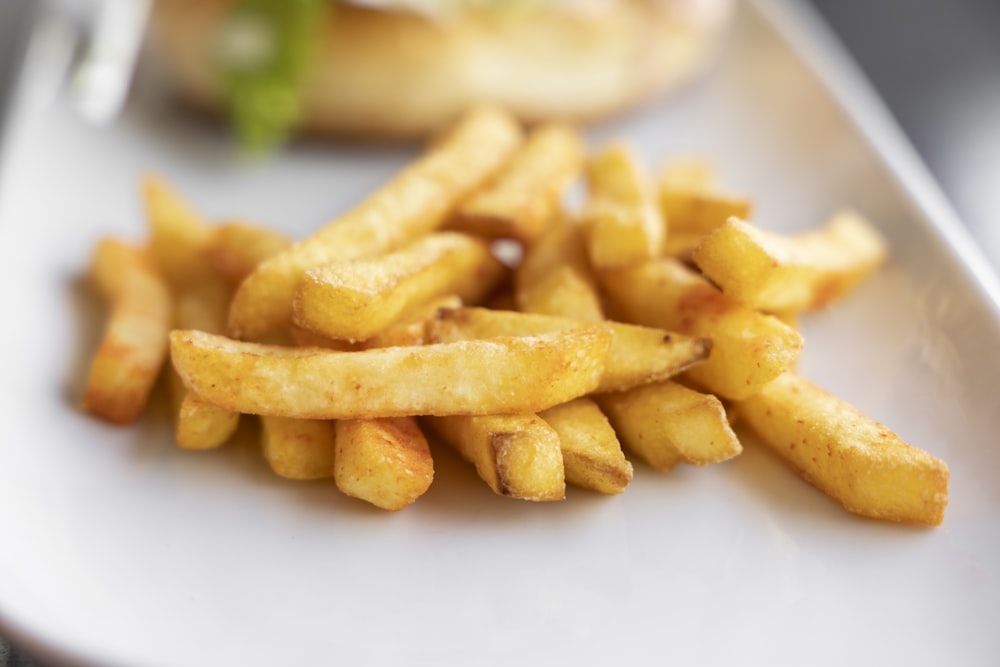 a white plate topped with french fries next to a sandwich