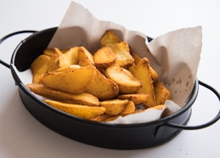 a black pan filled with potatoes on top of a table