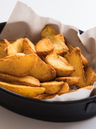 a black pan filled with potatoes on top of a table