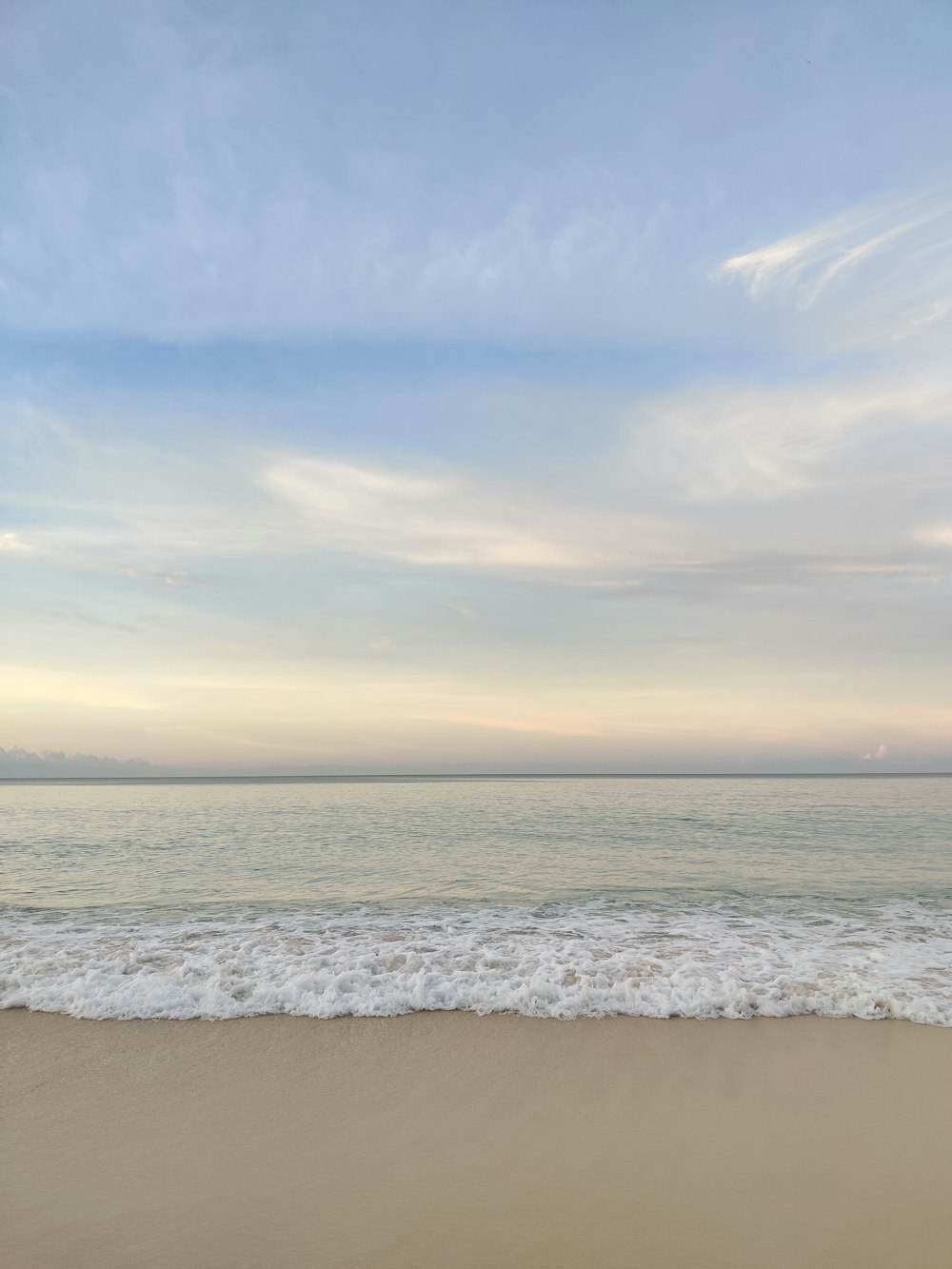 a sandy beach with waves coming in to shore