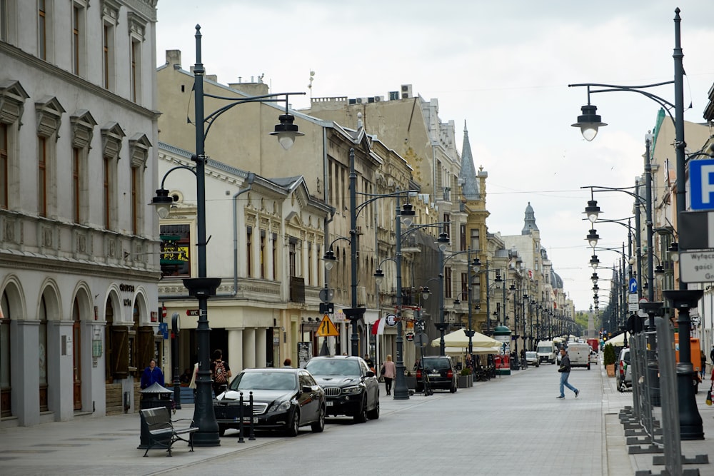 a city street lined with parked cars and tall buildings