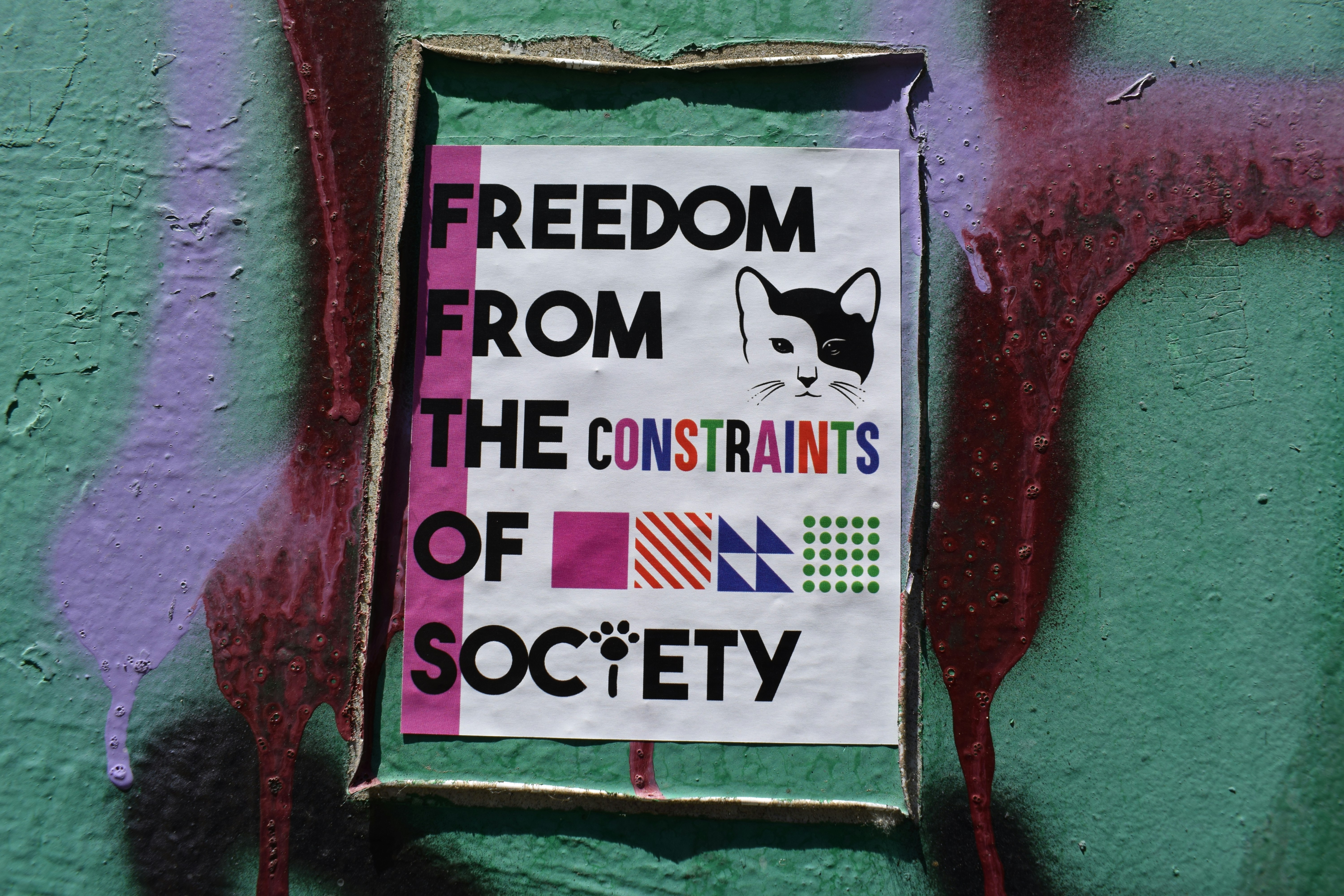 a sign on the side of a green wall