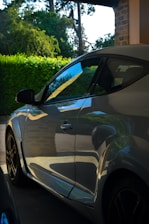 A sleek, modern car parked in a serene natural setting with soft morning light.