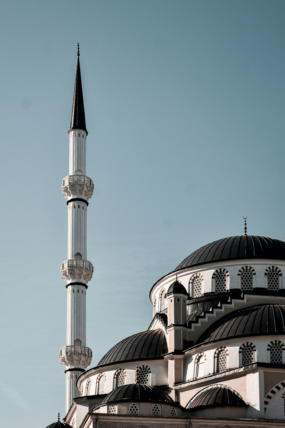 a tall white building with a black roof