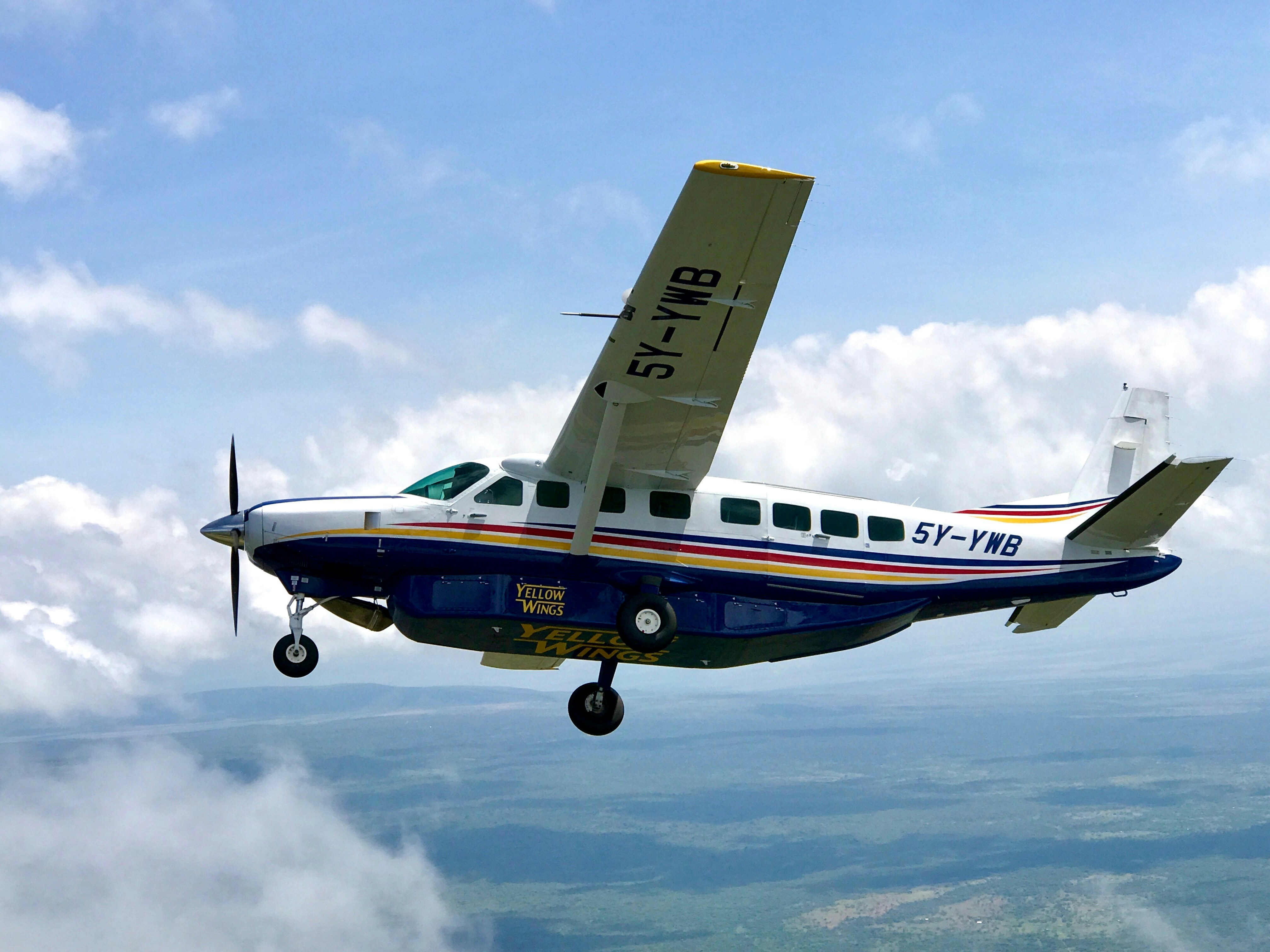 a small blue and white plane flying in the sky, 