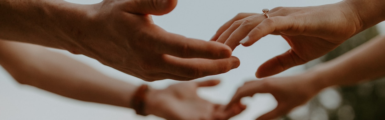 a group of people reaching out their hands