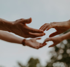 a group of people reaching out their hands