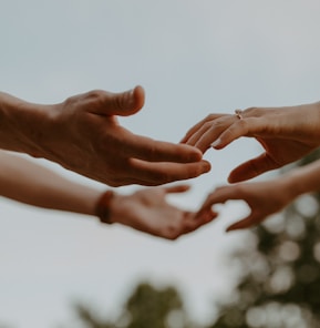 a group of people reaching out their hands