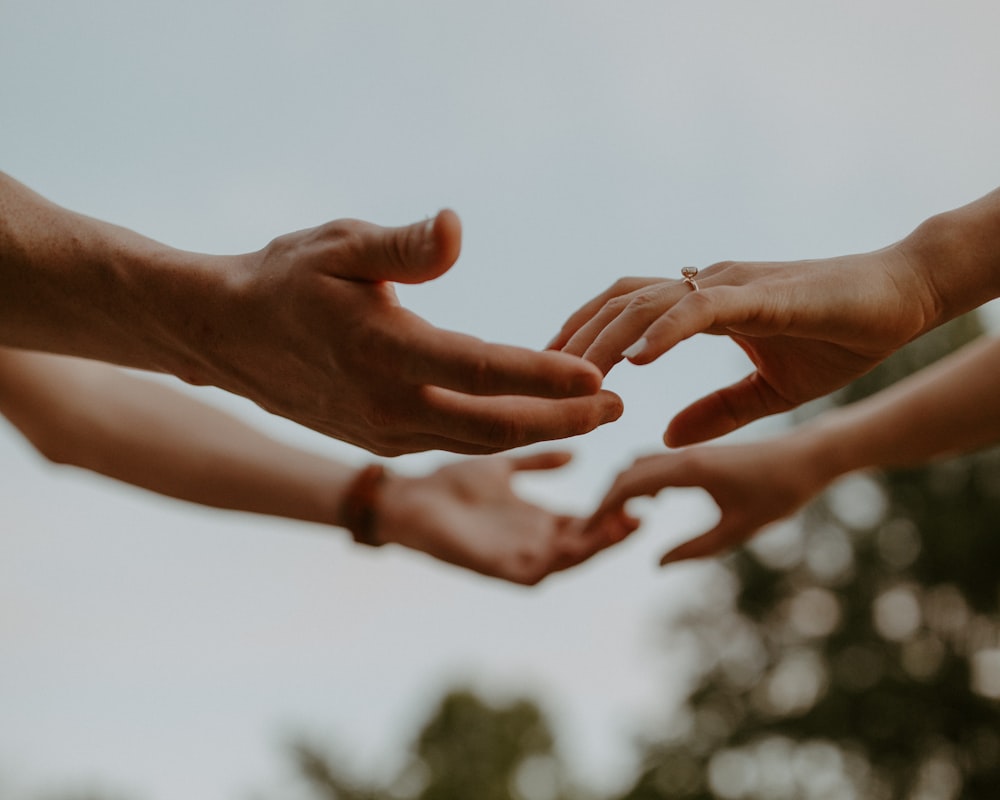 a group of people reaching out their hands