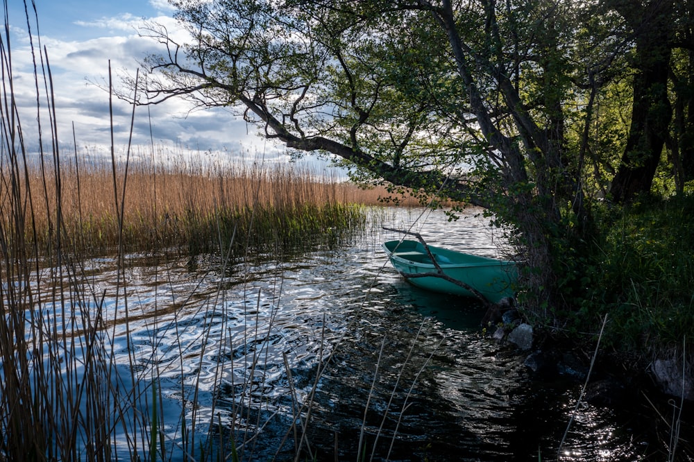 a small blue boat floating on top of a lake