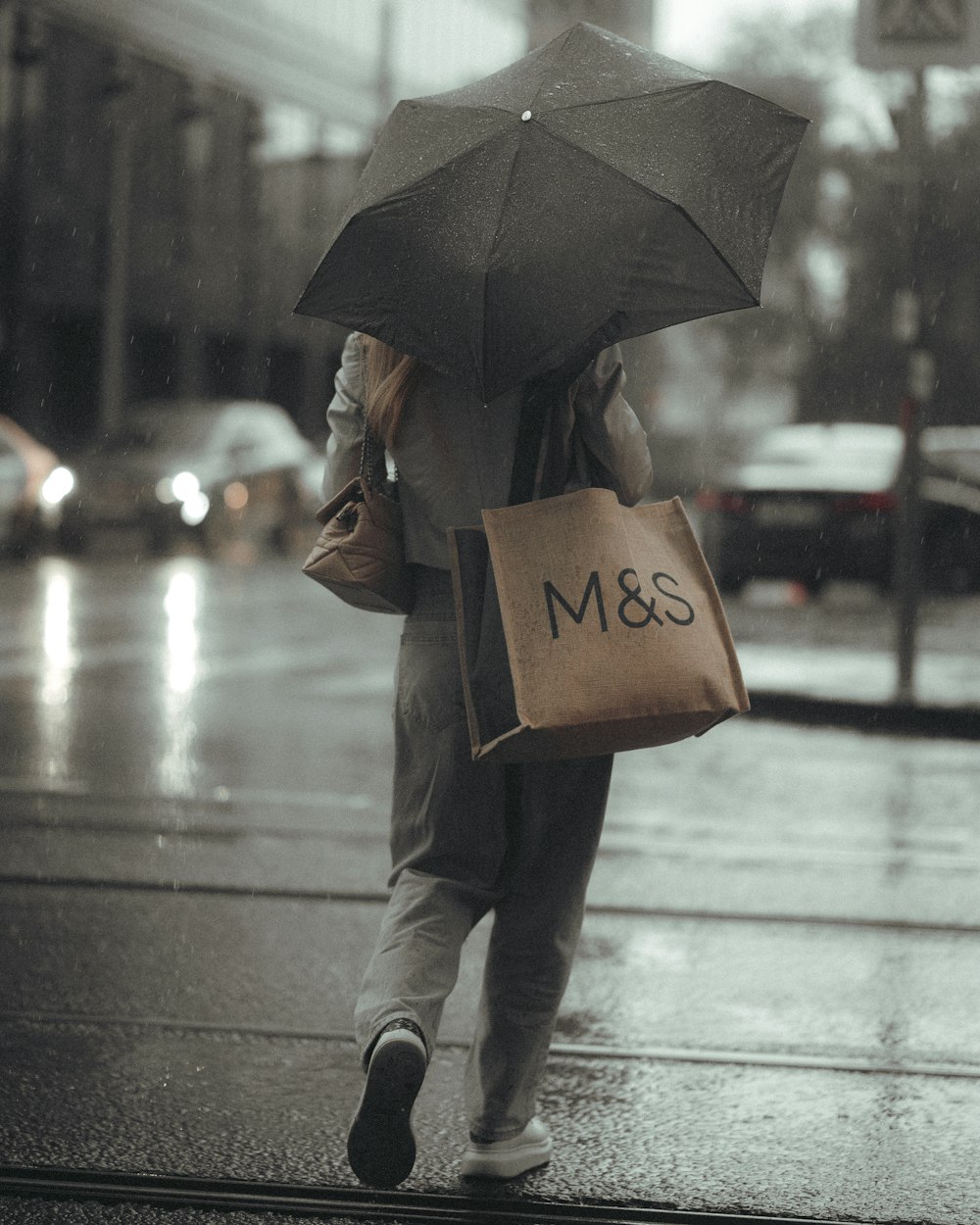 a woman walking down a street holding an umbrella