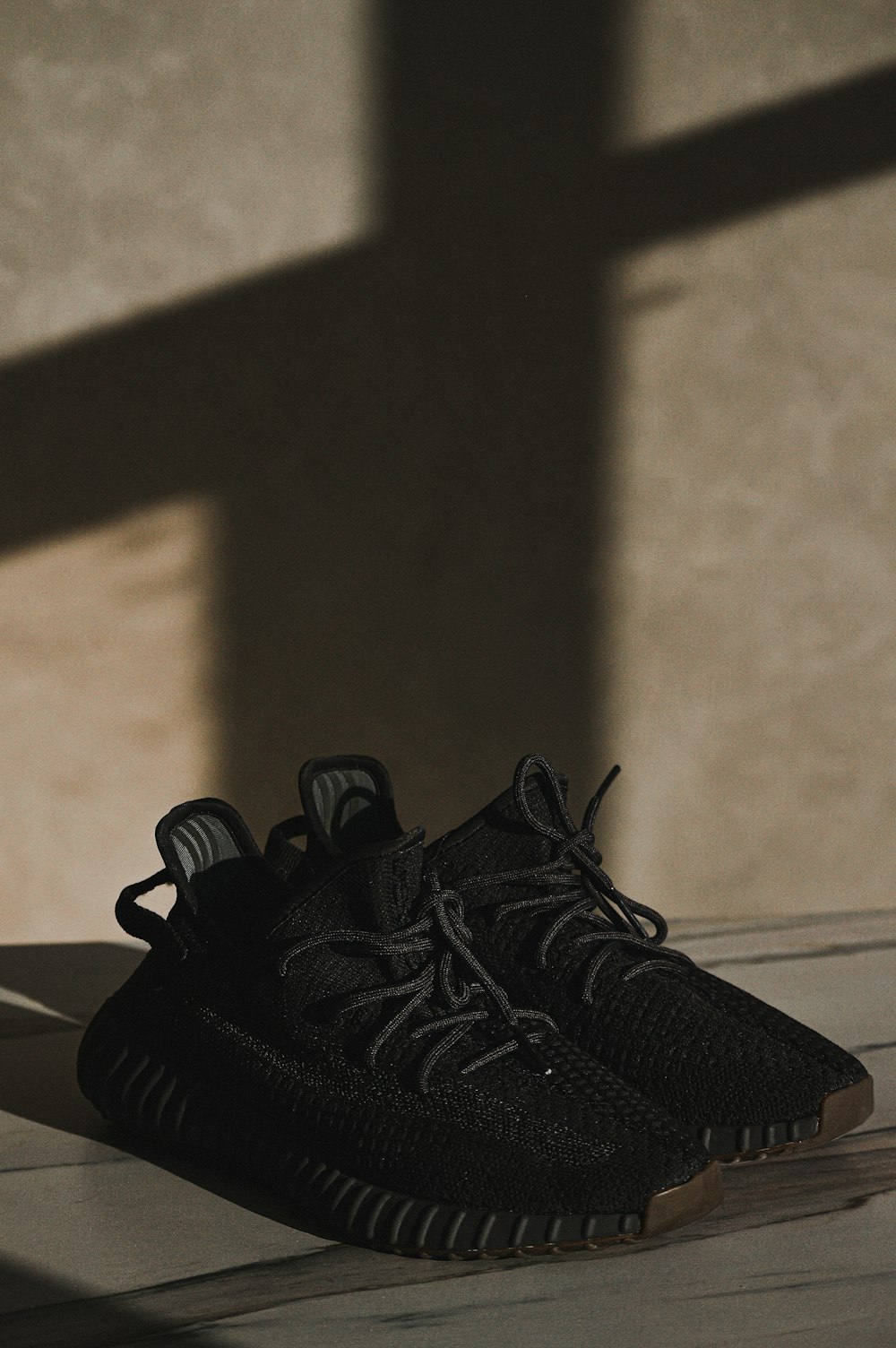 une paire de chaussures noires posées sur un plancher en bois