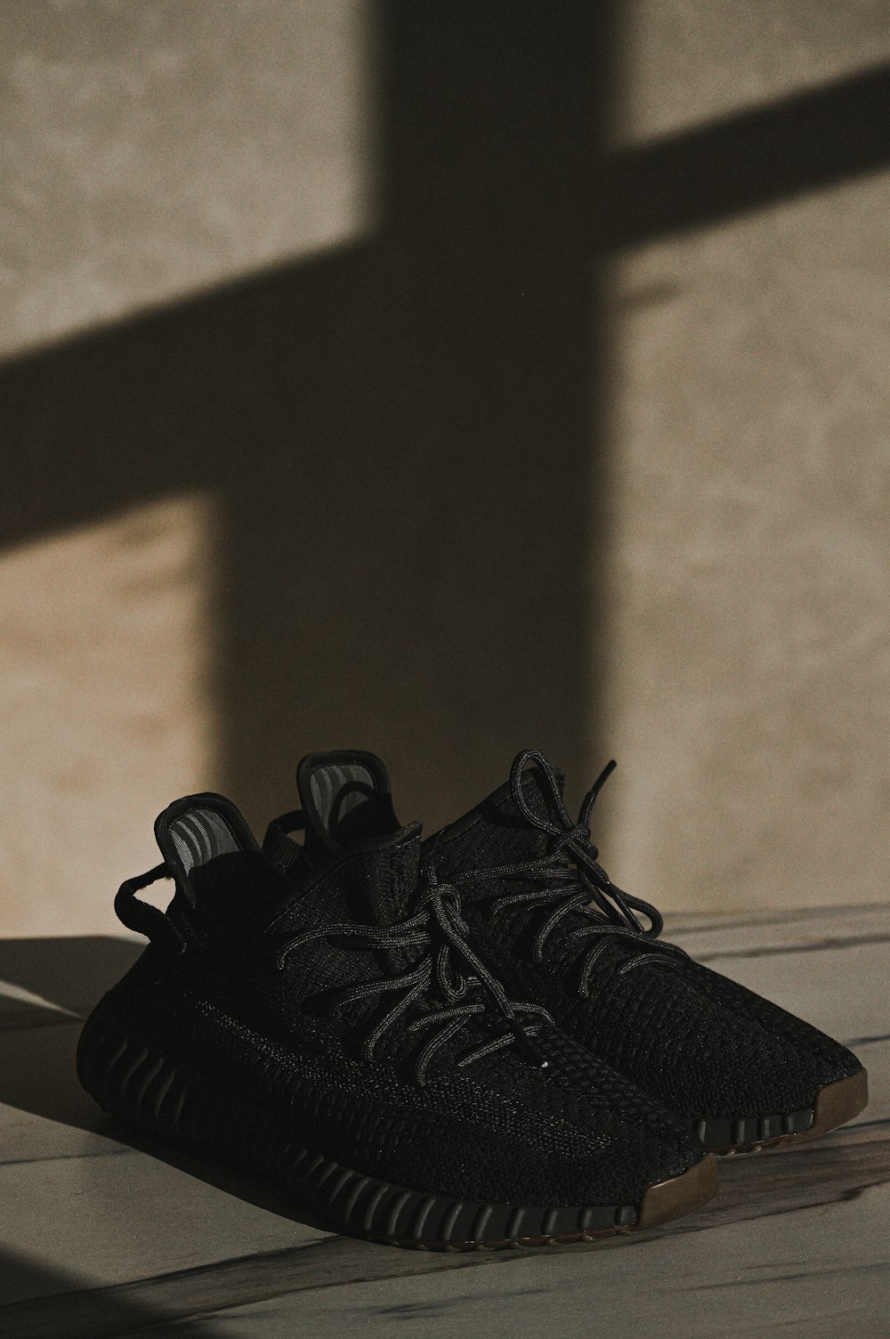 a pair of black shoes sitting on top of a wooden floor