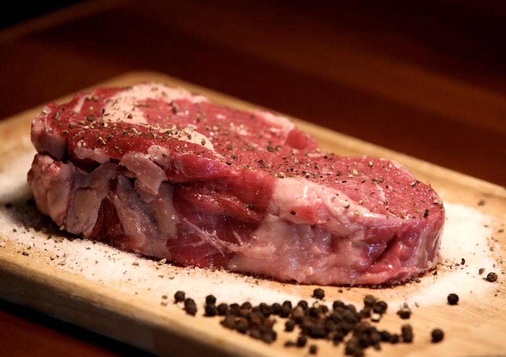 um pedaço de carne crua em uma tábua de corte